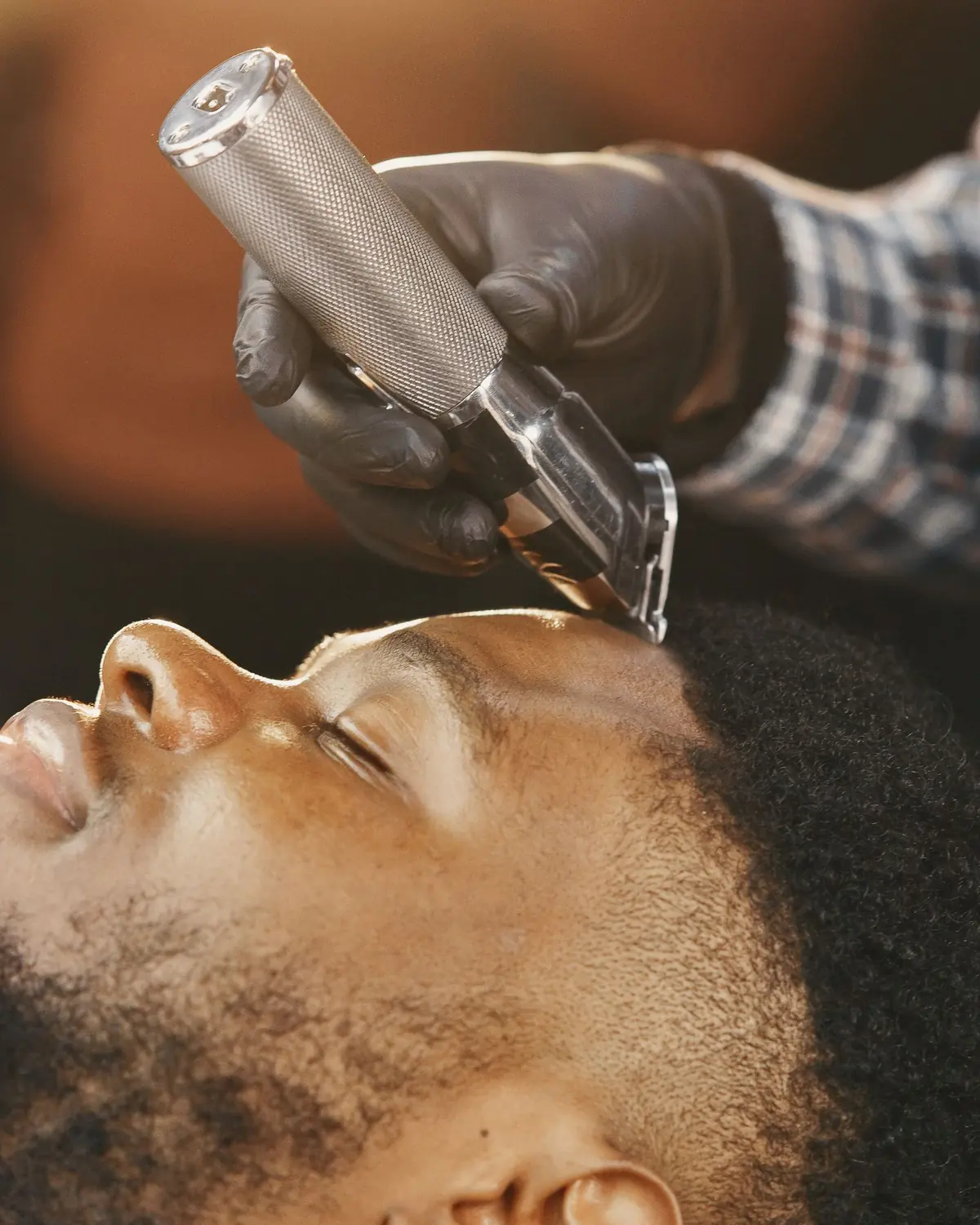 Barber finishing a fade with clippers